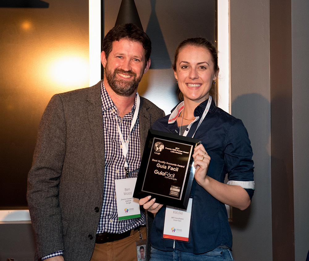 Karina, coordenadora de marketing e relacionamento, recebe o prêmio na sede da Google, nos EUA, ao lado do Diretor de Parcerias de Canais do Vendas do Google para Américas e Canadá, Ben Wood.